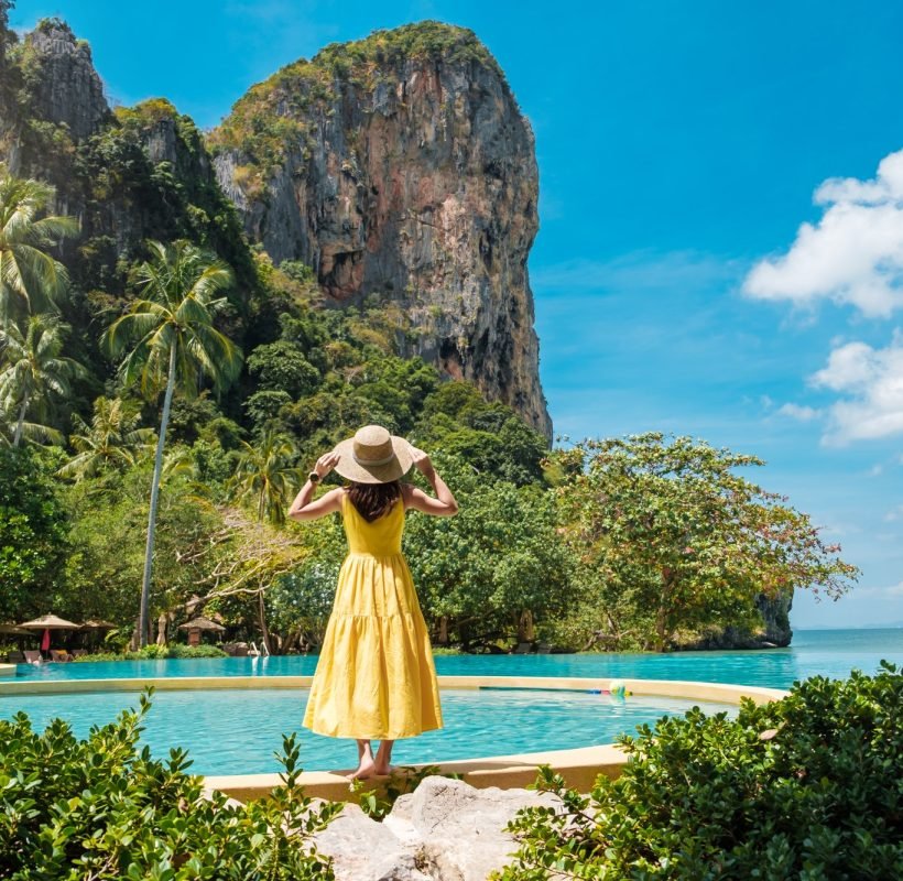 woman-tourist-in-yellow-dress-and-hat-traveling-on-railay-beach-krabi-thailand-vacation-travel.jpg